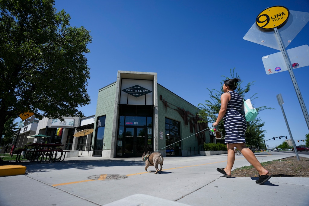 (Bethany Baker  |  The Salt Lake Tribune) A woman walks her dog toward Central 9th Market in Salt Lake City on Thursday, July 10, 2025.