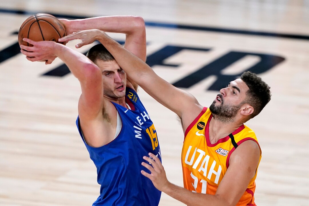 Denver Nuggets' Nikola Jokic (15) keeps the ball from Utah Jazz's Georges Niang (31) during the first half of an NBA basketball first round playoff game Sunday, Aug. 30, 2020, in Lake Buena Vista, Fla. (AP Photo/Ashley Landis)