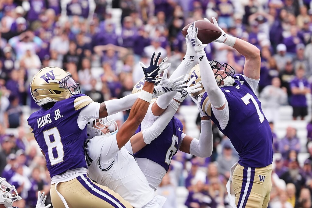 Washington safety Alex McLaughlin (7) deflects a pass in the end zone with cornerback Dylan Robinson (6) and cornerback Ramonz Adams Jr. (8) against Utah State wide receiver Anthony Garcia and tips it to teammate Rahshawn Clark (not pictured) for an interception during the second half of an NCAA college football game Saturday, Sept. 12, 2026, in Seattle. (AP Photo/Lindsey Wasson)