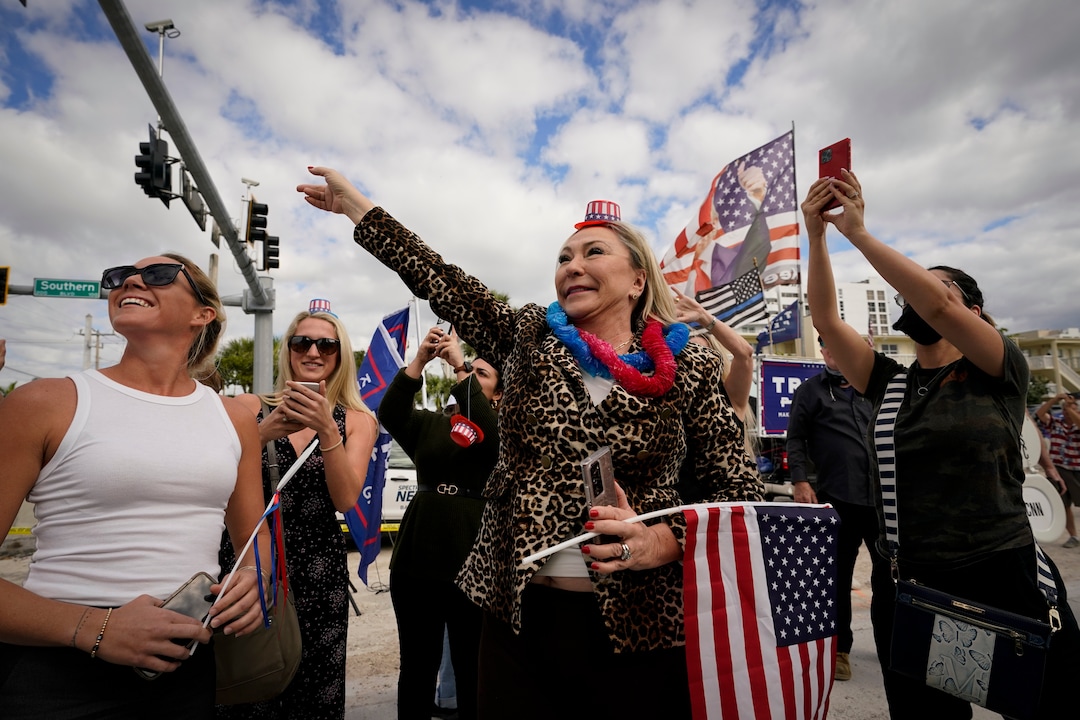 Heidi Forte, middle, with other supporters of President Donald Trump wait for the motorcade on the road to Mar-a-Lago, Trump's Palm Beach estate, on Wednesday, Jan. 20, 2021, in West Palm Beach, Fla. (AP Photo/Lynne Sladky)