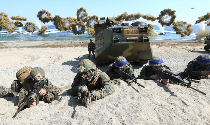 FILE - In this March 12, 2016 file photo, Marines of the U.S., left, and South Korea wearing blue headbands on their helmets, take positions after landing on a beach during the joint military combined amphibious exercise, called Ssangyong, part of the Key Resolve and Foal Eagle military exercises, in Pohang, South Korea. America’s annual joint military exercises with South Korea always frustrate North Korea. The war games set to begin Monday, Aug. 21, 2017 may hold more potential to provoke than ever, given President Donald Trump’s “fire and fury” threats and Pyongyang’s as-yet-unpursued plan to launch missiles close to Guam. (Kim Jun-bum/Yonhap via AP, File)