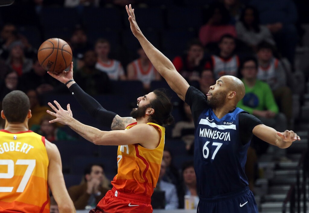 Utah Jazz's Ricky Rubio, left, of Spain, lays up in front of Minnesota Timberwolves' Taj Gibson in the second half of an NBA basketball game Sunday, Jan. 27, 2019, in Minneapolis.  (AP Photo/Jim Mone)