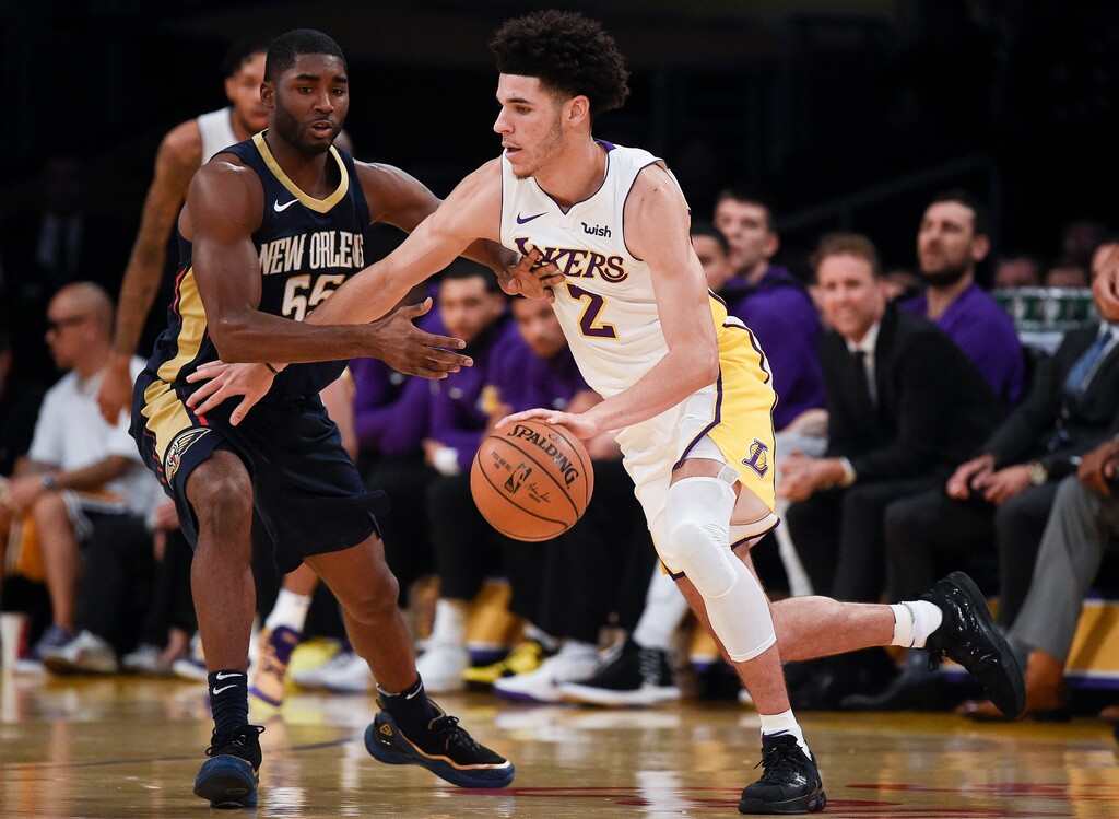 Los Angeles Lakers guard Lonzo Ball, right, moves the ball around New Orleans Pelicans guard E'Twaun Moore during the first half of an NBA basketball game in Los Angeles, Sunday, Oct. 22, 2017. (AP Photo/Kelvin Kuo)