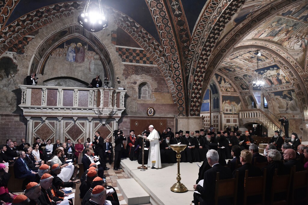 (Tiziana Fabi/Pool Photo via AP, File) In this Tuesday, Sept. 20, 2016, Pope Francis, standing, leads a prayer with representatives of different religions, inside the Basilica of St. Francis, in Assisi, Italy. The Franciscan friars in Assisi say Pope Francis will journey there next month to sign a new encyclical, expected to stress the value of brotherly relations during and after the pandemic, in what could be his first visit outside of the Rome area since Italy went into lockdown.