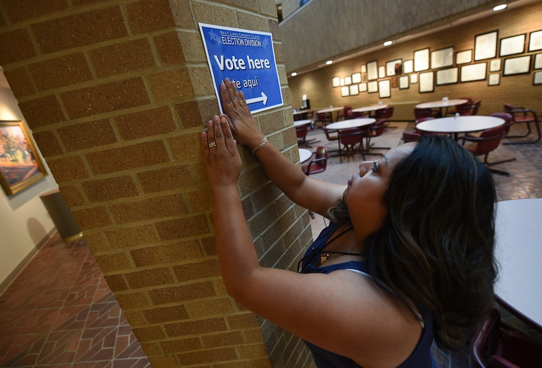 (Francisco Kjolseth  |  The Salt Lake Tribune)  Poll worker Annabel Garcia puts up signs to direct people who arrive to vote at the Salt Lake County complex for primary election day on Tuesday, June 26, 2018.
