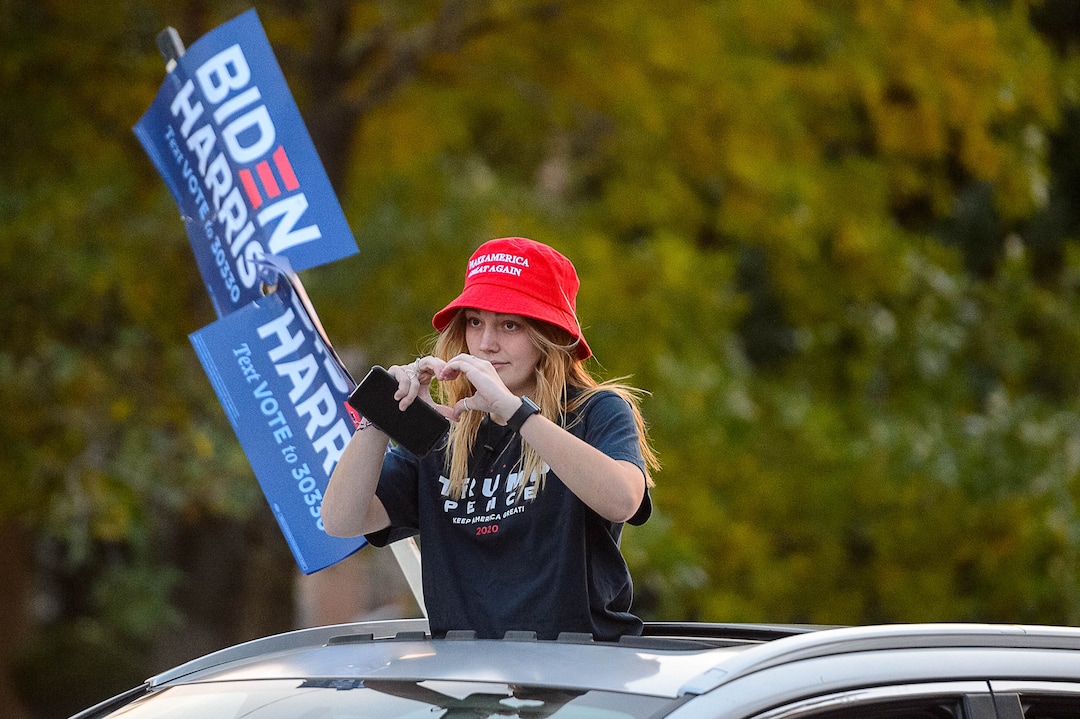 (Trent Nelson  |  The Salt Lake Tribune) A woman in a Trump t-shirt signals to protesters as Vice President Mike Pence and Sen. Kamala Harris prepare to debate at Kingsbury Hall in Salt Lake City on Wednesday, Oct. 7, 2020.