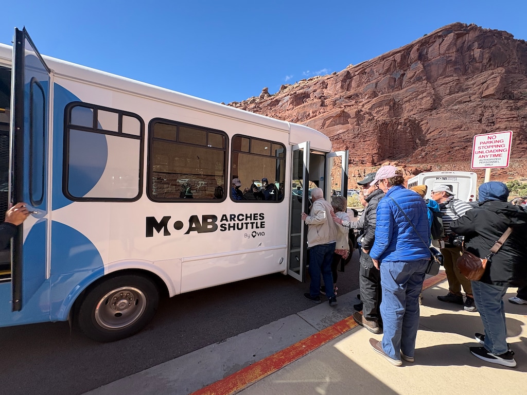 (Andrew Christiansen | The Times-Independent) Passengers board the Moab-Arches shuttle at the Arches Visitor Center on Oct. 15. Riders interviewed that day described experiences ranging from short waits and easy navigation to delays that limited their plans.
