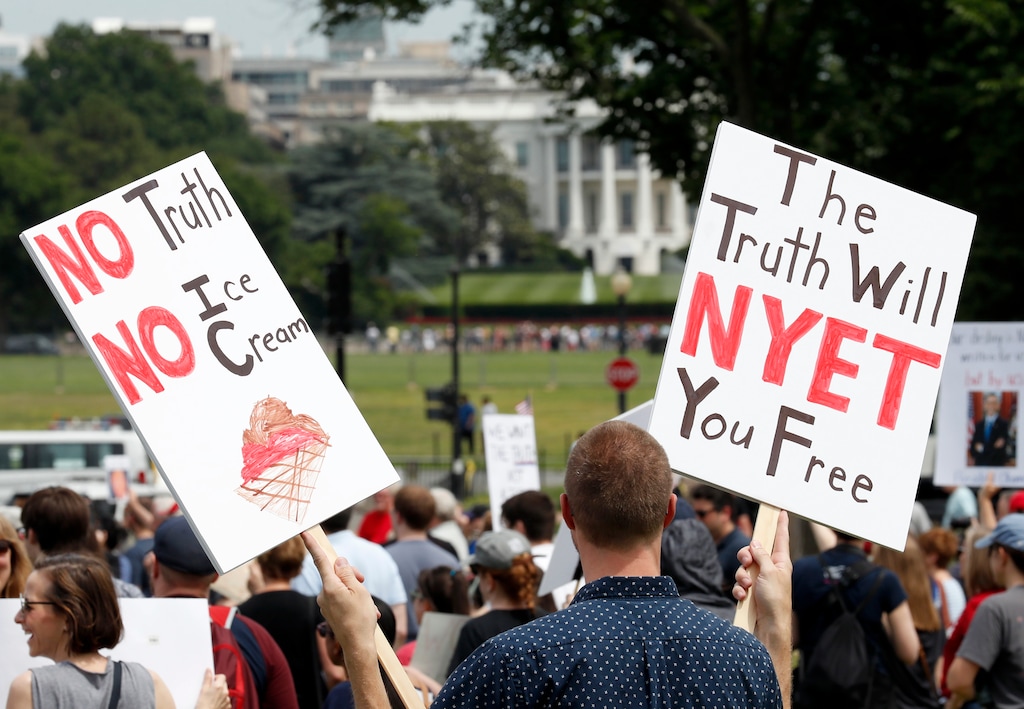 (Alex Brandon | The Associated Press) A protester holds signs during a rally to protest President Donald Trump and his policies, on the National Mall, Saturday, June 3, 2017, in Washington.