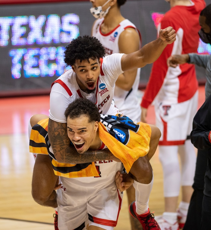 (Doug McSchooler | AP) Texas Tech guard Kyler Edwards (11) catches a ride on the back of teammate forward Marcus Santos-Silva (14) as the two celebrate their win over Utah State in a first round game in the NCAA men's college basketball tournament, Friday, March 19, 2021, at Assembly Hall in Bloomington, Ind.