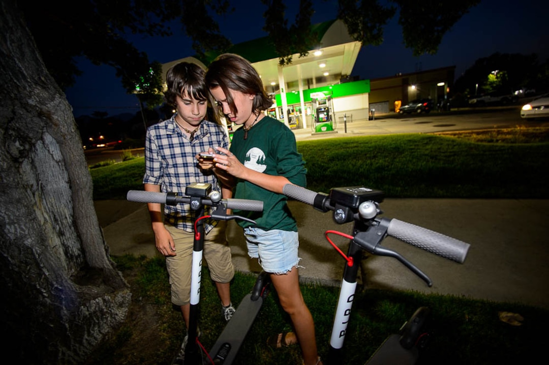 (Trent Nelson | The Salt Lake Tribune) Chase and Ady Hein capture scooters in Salt Lake City  Tuesday Aug. 7, 2018. Their mother, Jenn Hein, works as a "Bird charger" on the side to make some extra cash, picking up and charging electric scooters overnight and returning them to the city streets in the early morning.