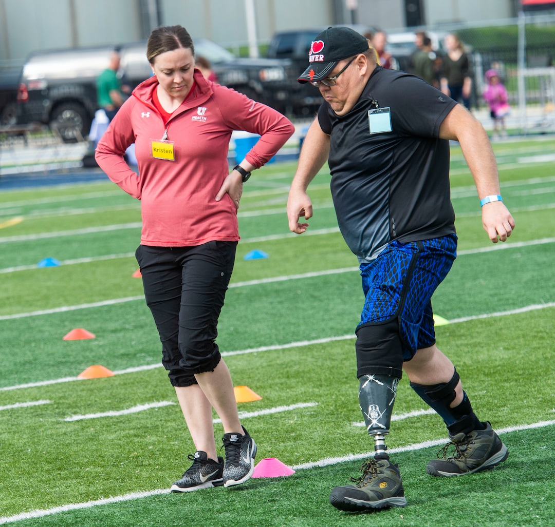 (Rick Egan  |  The Salt Lake Tribune)      Kristen Black-Bain assists Jeremy Wayman, from Kearns, during the fourth annual Utah Adaptive Mobility Clinic at Skyline High school. The clinic allows anyone with "lower extremity limb loss or limb difference" or amputees without legs, to practice walking and running. Saturday, June 1, 2019.