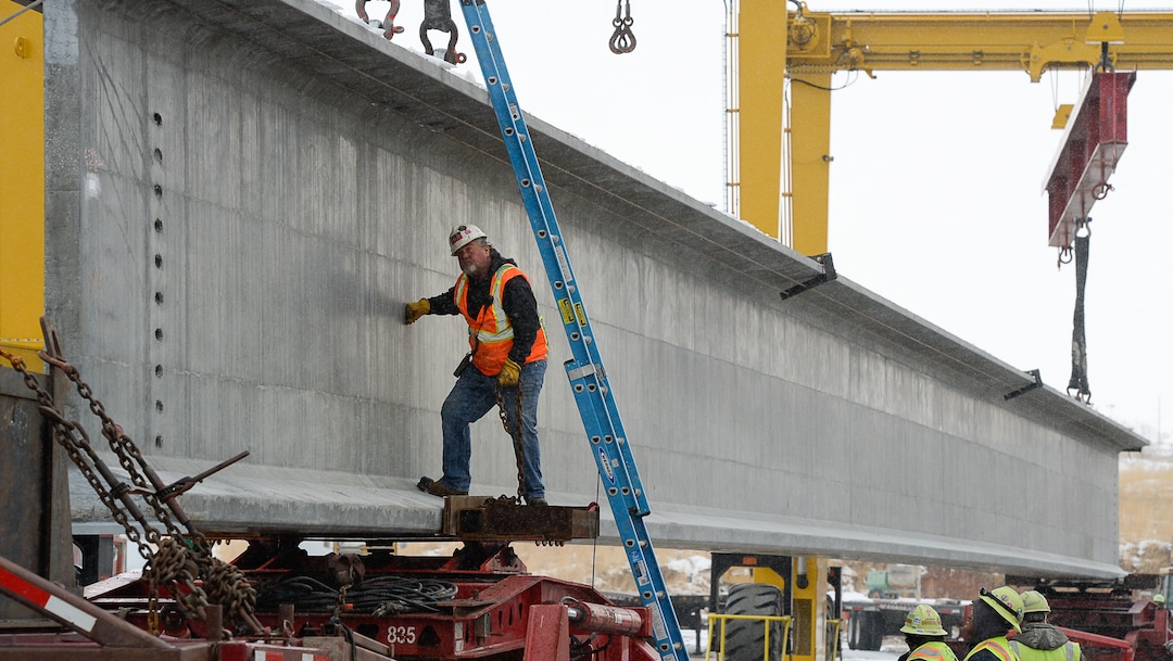 (Francisco Kjolseth  |  The Salt Lake Tribune)  UDOT gets ready to place some of the world's largest-ever bridge beams, and the largest in Utah state history with a span of 203 ft long and just over 8 ft tall, as crews load one on a truck following manufacturing at Forterra Structural Precast in Kearns on Tuesday, Dec. 11, 2018. A total of six beams will be installed in the technology corridor in Lehi later this week.