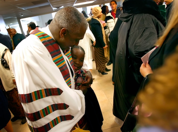 (Chris Detrick | Tribune file photo) The Rev. France Davis hugs Janelle Douglas, 6, following the worship service Sunday morning at Calvary Baptist Church, Dec. 31, 2006.