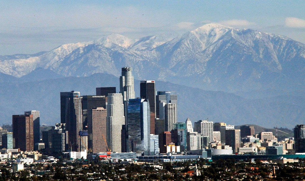 (AP Photo | Nick Ut, File) In this Dec. 31, 2014, file photo, the snow-capped San Gabriel Mountains provide a backdrop to the downtown Los Angeles skyline as seen from Kenneth Hahn State Recreation Area in Baldwin Hills. California greenhouse gas emissions fell below 1990 levels, meeting an early target years ahead of schedule and putting the state well on its way toward reaching long-term goals to fight climate change, officials said Wednesday, July 11, 2018.