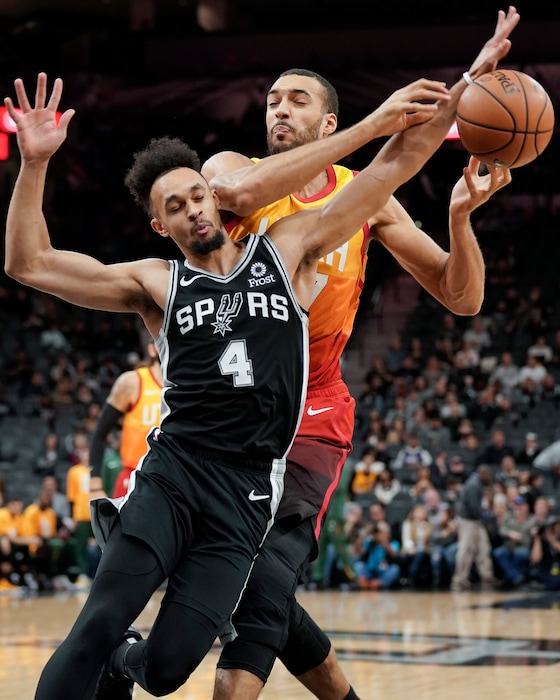 Utah Jazz center Rudy Gobert, right, collides with San Antonio Spurs guard Derrick White during the first half of an NBA basketball game, Sunday, Dec. 9, 2018, in San Antonio. (AP Photo/Darren Abate)