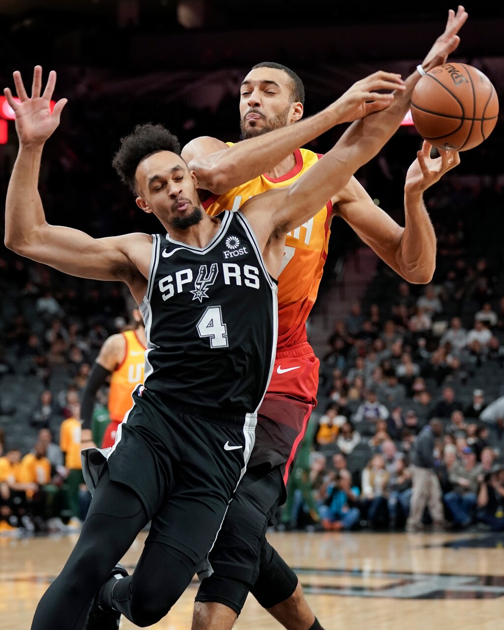 Utah Jazz center Rudy Gobert, right, collides with San Antonio Spurs guard Derrick White during the first half of an NBA basketball game, Sunday, Dec. 9, 2018, in San Antonio. (AP Photo/Darren Abate)