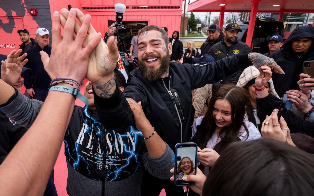 (Rick Egan | The Salt Lake Tribune) Post Malone, greets fans as he arrives for the opening of new Raising Cane's in Fort Union, on Thursday, April 13, 2023. The Midvale location was designed by Malone.