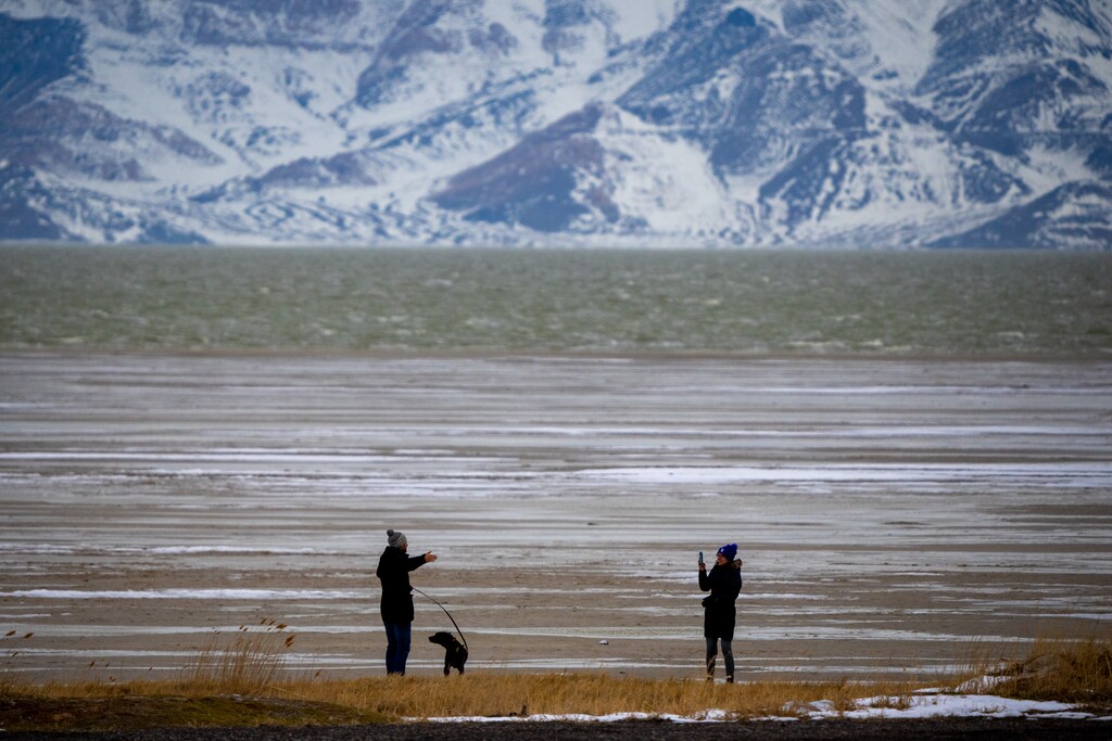 (Trent Nelson | The Salt Lake Tribune) A couple on the shores of the Great Salt Lake, with Stansbury Island in the background, on Monday February 27, 2023.