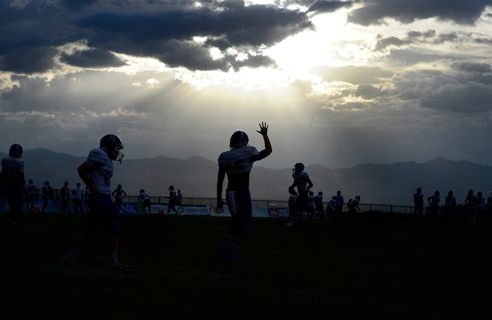 (Scott Sommerdorf  |  The Salt Lake Tribune)  Bingham player practice under the threatening weather as Brighton hosted rival Bingham in a 5A game played Friday, September 26, 2014. The game was halted for thirty minutes in the first half due to lightning in the area.