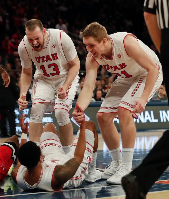 Utah forward David Collette (13) and forward Tyler Rawson (21) react after guard Justin Bibbins (1) drew an offensive foul on Western Kentucky guard Lamonte Bearden during the second half of an NCAA college basketball game during the semifinals of the NIT, Tuesday, March 27, 2018, in New York. Utah won 69-64. (AP Photo/Julie Jacobson)