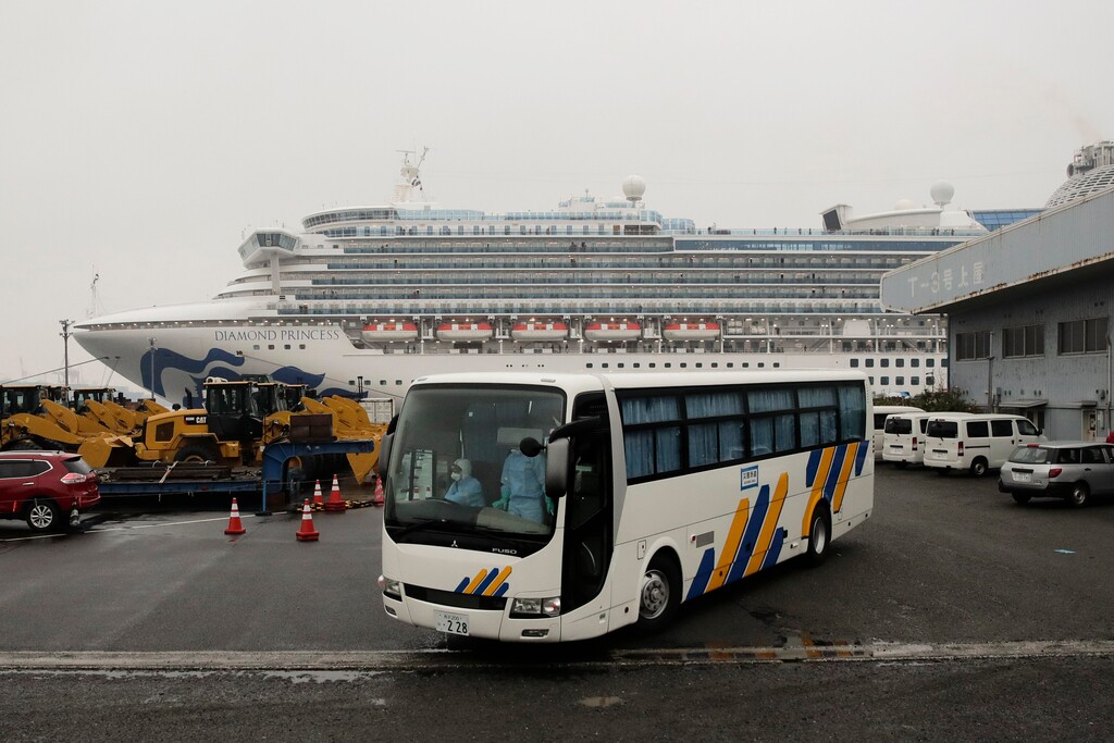 (Jae C. Hong | The Associated Press) A bus leaves the quarantined Diamond Princess cruise ship at a port Sunday, Feb. 16, 2020, in Yokohama, near Tokyo. The U.S. says Americans aboard a quarantined ship will be flown back home on a chartered flight Sunday, but that they will face another two-week quarantine.