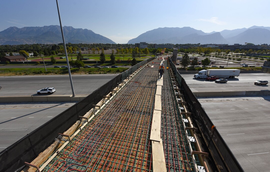 (Francisco Kjolseth  |  The Salt Lake Tribune) UDOT gives a tour of the state’s new longest pedestrian bridge on Thursday, August 20, 2020, connecting Utah Valley University in Orem to student housing and the community on the West side of I-15. Crews are finishing up an extensive hydronic heating system that will pump warm water to keep the bridge clear of snow in the winters, as it gets ready to pour concrete for the walking surface. UDOT will close I-15 in both directions this weekend for work on the nearly 1,000 foot bridge that is 15 feet wide to accommodate pedestrians, cyclists and scooters. Elevators and stairs with small ramps to push up bicycles will be on each side of the bridge.