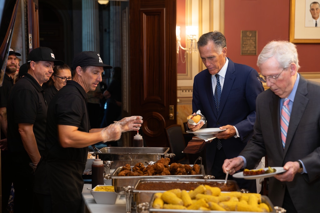 (Romney Press Office) Senators Mitt Romney and Mitch McConnell load their plates with food straight from Utah, including Provo-based J. Dawgs, on Thursday, July 25, 2024.