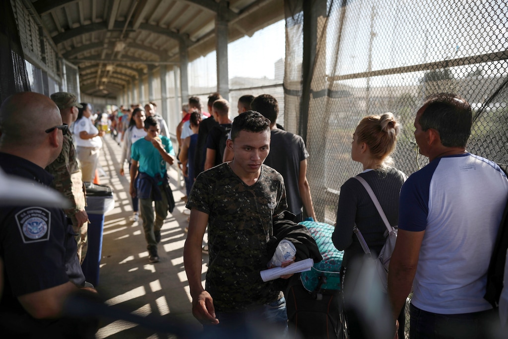 (Emilio Espejel | AP file photo)  Migrants return to Mexico as other migrants line up on their way to request asylum in the U.S., at the foot of the Puerta Mexico bridge in Matamoros, Mexico, that crosses into Brownsville, Texas, on Aug. 2, 2019.