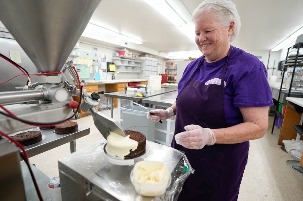 (Francisco Kjolseth | The Salt Lake Tribune) Owner Laurlee Morrison uses an automated frosting machine to spread butter cream over a chocolate cake at Cakes de Fleur in South Salt Lake on Tuesday, July 11, 2023.