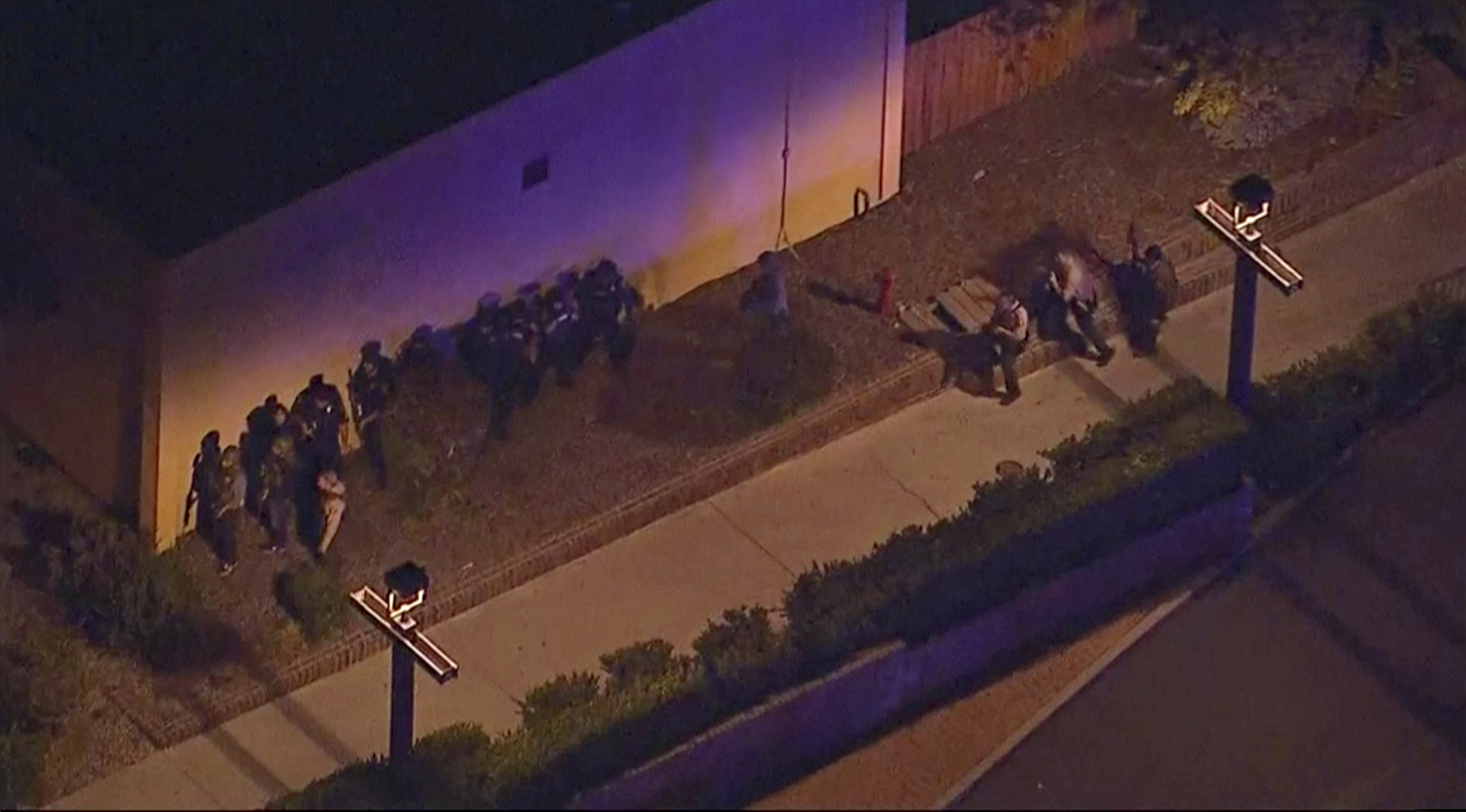 In this image made from aerial video, police move through the vicinity of a shooting in Thousand Oaks, California, early Thursday, Nov. 8, 2018. Authorities say there were multiple injuries - including one officer - after a man opened fire in Southern California bar late Wednesday. (KABC via AP)