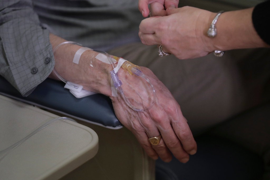 (Charles Krupa | The Associated Press) A patient with Alzheimer's disease, rests his arm during his infusion while participating in a study.