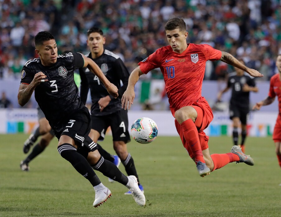 United States midfielder Christian Pulisic, right, controls the ball against Mexico defender Carlos Salcedo during the first half of the CONCACAF Gold Cup final soccer match at Soldier Field in Chicago, Sunday, July 7, 2019. (AP Photo/Nam Y. Huh)
