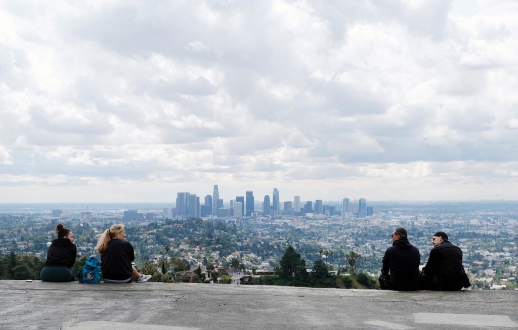 Two pairs of hikers maintain distance as they mingle at Vista View Point in Griffith Park, Friday, March 20, 2020, in Los Angeles. California Gov. Gavin Newsom issued a statewide stay-at-home order Thursday for residents to venture outside only for essential jobs, errands and some exercise, due to coronavirus concerns. (AP Photo/Chris Pizzello)