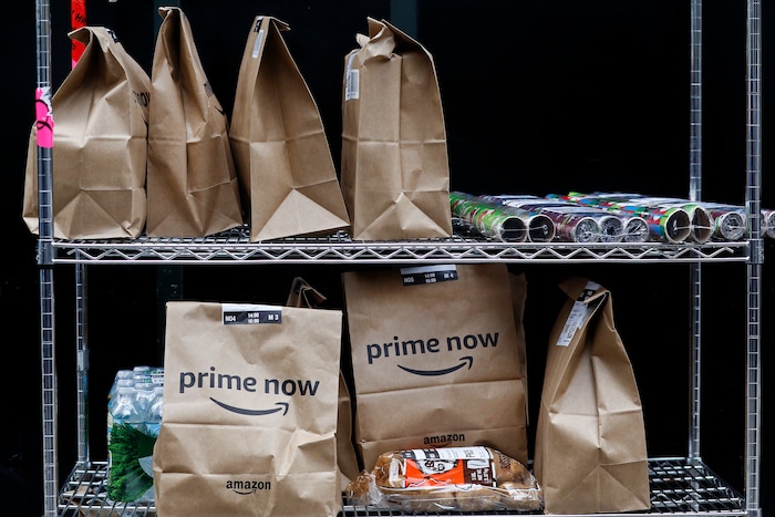 In this Wednesday, Dec. 20, 2017, photo, Amazon Prime Now bags are ready for delivery, at the Amazon warehouse in New York. (AP Photo/Mark Lennihan)