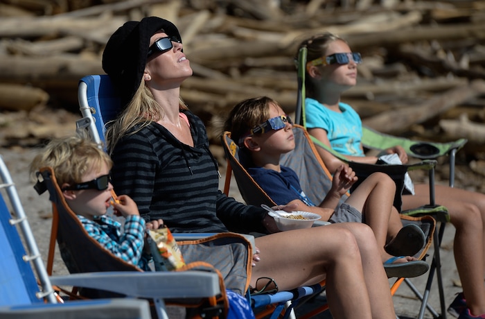 (Francisco Kjolseth  |  The Salt Lake Tribune)  Kristi Wechsler of Huntington Beach, CA, is joined by her children, Jude, 3, Gavin, 6, and Sarina, 8, as they watch the moon take in the total eclipse of the sun from the edge of Palisades Reservoir, Idaho, on Monday, August 21, 2017.