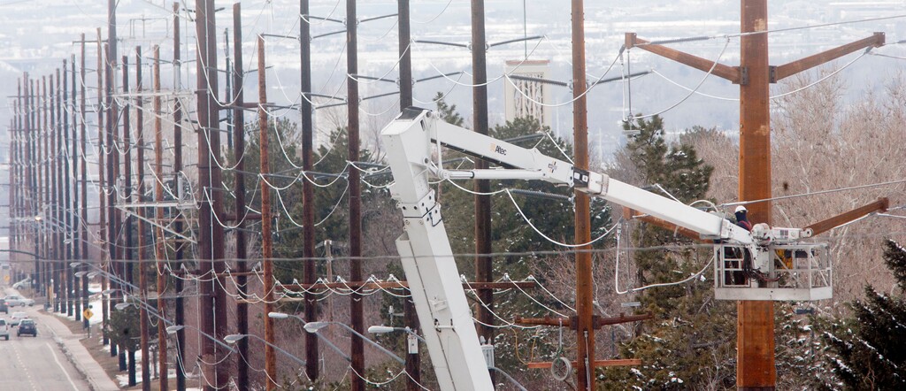 (Steve Griffin | Tribune file photo) A Rocky Mountain Power crew works on power lines in Salt Lake City in 2013. Rates will drop about 0.7% in January, Rocky Mountain Power announced in a news statement Thursday.