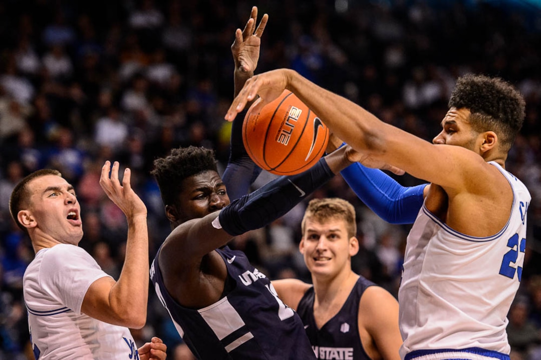 (Trent Nelson | The Salt Lake Tribune)  Utah State Aggies center Neemias Queta (23) defended by Brigham Young Cougars guard Zac Seljaas (2) and Brigham Young Cougars forward Yoeli Childs (23) as BYU hosts Utah State, NCAA basketball in Provo on Wednesday Dec. 5, 2018.