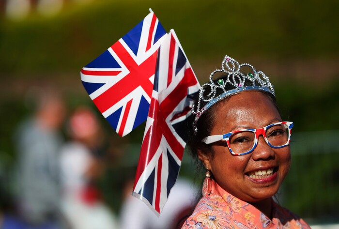 A Royal fan smiles as she stands near the Long Walk before the wedding ceremony of Prince Harry and Meghan Markle at St. George's Chapel in Windsor Castle in Windsor, near London, England, Saturday, May 19, 2018. (Hannah McKay/pool photo via AP)