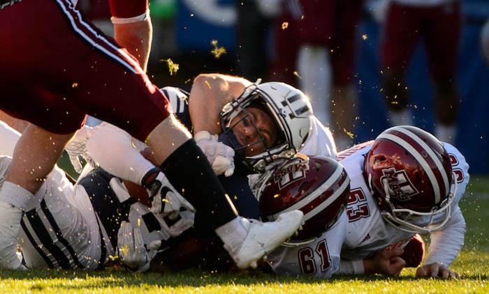 (Trent Nelson | The Salt Lake Tribune)  Brigham Young Cougars defensive back Michael Shelton (18) is tackled by Massachusetts Minutemen defensive lineman Joe Previte (61) as BYU hosts the University of Massachusetts, NCAA football in Provo, Saturday November 18, 2017.