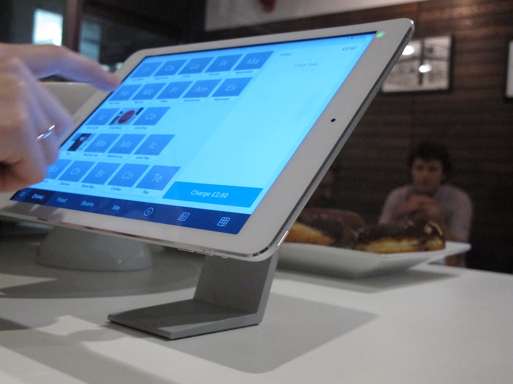 In this Thursday, Nov. 20, 2014, image Catherine Seay demonstrates the use of Square point-of-sale software at the Curators Coffee Gallery in central London. The financial services startup is taking aim at cash registers across the globe, making its point-of-sale software available internationally in English, Spanish, French and Japanese. (AP Photo/Raphael Satter)