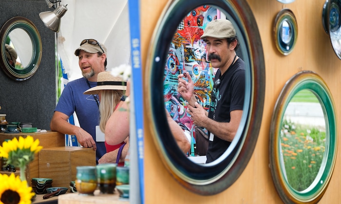 (Francisco Kjolseth  |  The Salt Lake Tribune)  Artists James Diem, left, and Darrell Driver talk to customers while displaying their work side by side during the annual 2019 Utah Arts Festival as it kicks off at Library Square and Washington Square in downtown Salt Lake City, Thursday, June 20, 2019, with visual and performance art of all varieties and food for all ages from June 20-23.