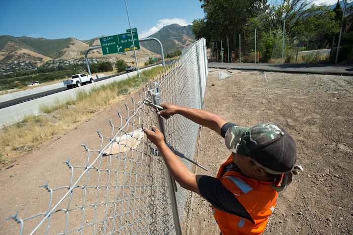 (Rick Egan | The Salt Lake Tribune) Ronie Ocha installs a chain-link fence along a new segment of Parley's Trail in Salt Lake City on Wednesday, Aug. 30, 2017.