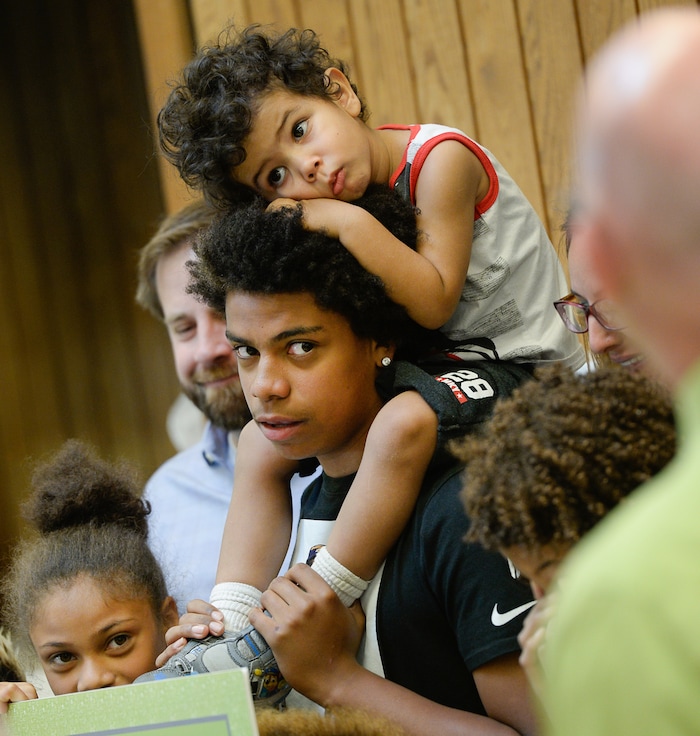 (Francisco Kjolseth  |  The Salt Lake Tribune)  Kearns High sophomore Keeven Wilson, 16, with brother Kinston, 3, on top, gathers for family photos after being announced as Granite School District's Absolutely Incredible Kid award winner during the school farewell assembly on Tuesday, May 22, 2018. Wilson who had a particularly difficult home life, to the point that he and his siblings were taken away from his parents and near universal F's during his junior high days turned his life around.  With the help of a new foster family, teachers and his football coach, he is now an honor roll student and thinking of studying psychology in college.