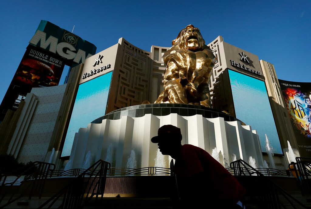FILE - In this Aug. 3, 2015, file photo, a man rides his bike past the MGM Grand hotel and casino in Las Vegas.  The operator of the Mandalay Bay casino-resort from which a gunman carried out the largest mass shooting in U.S. history has filed federal lawsuits against hundreds of victims.  MGM Resorts International argues in lawsuits filed Friday, July 13, 2018 in Nevada and California that it is has “no liability of any kind” to the defendants under a federal law enacted in the wake of 9/11 terrorist attacks.  (AP Photo/John Locher, File)