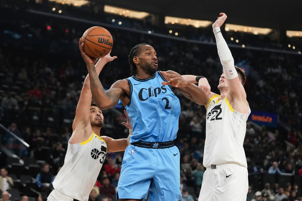 Los Angeles Clippers' Kawhi Leonard (2) looks to pass the ball under pressure by Utah Jazz's Johnny Juzang, left, and Kyle Filipowski, right, during the first half of an NBA basketball game Saturday, Feb. 8, 2025, in Inglewood, Calif. (AP Photo/Jae C. Hong)