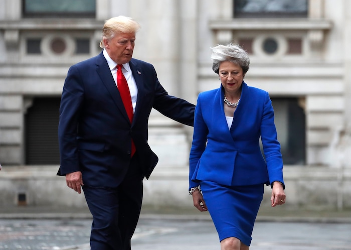 Britain's Prime Minister Theresa May and President Donald Trump walk through the Quadrangle of the Foreign Office for a joint press conference in central London, Tuesday, June 4, 2019. (AP Photo/Frank Augstein)