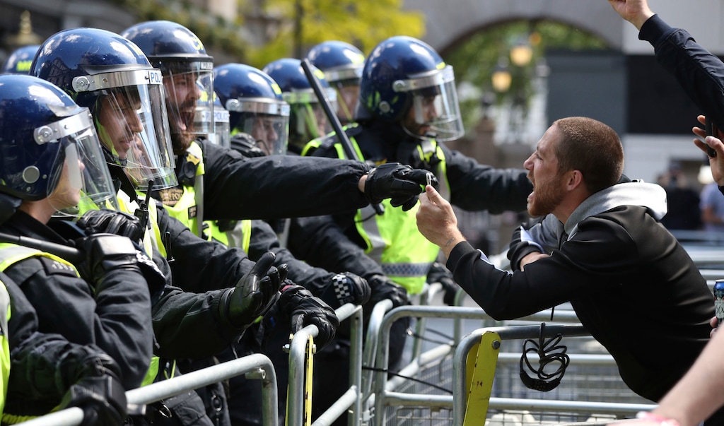 Police are confronted by a protester in Whitehall near Parliament Square, London, during a protest by the Democratic Football Lads Alliance against a Black Lives Matter protest, Saturday June 13, 2020. The death of George Floyd in the United States, has prompted demonstrations by far-right groups as well as the Black Lives Matter movement and provoked a wider debate regarding many historical figures and Britain's colonial past. (Jonathan Brady/PA via AP)