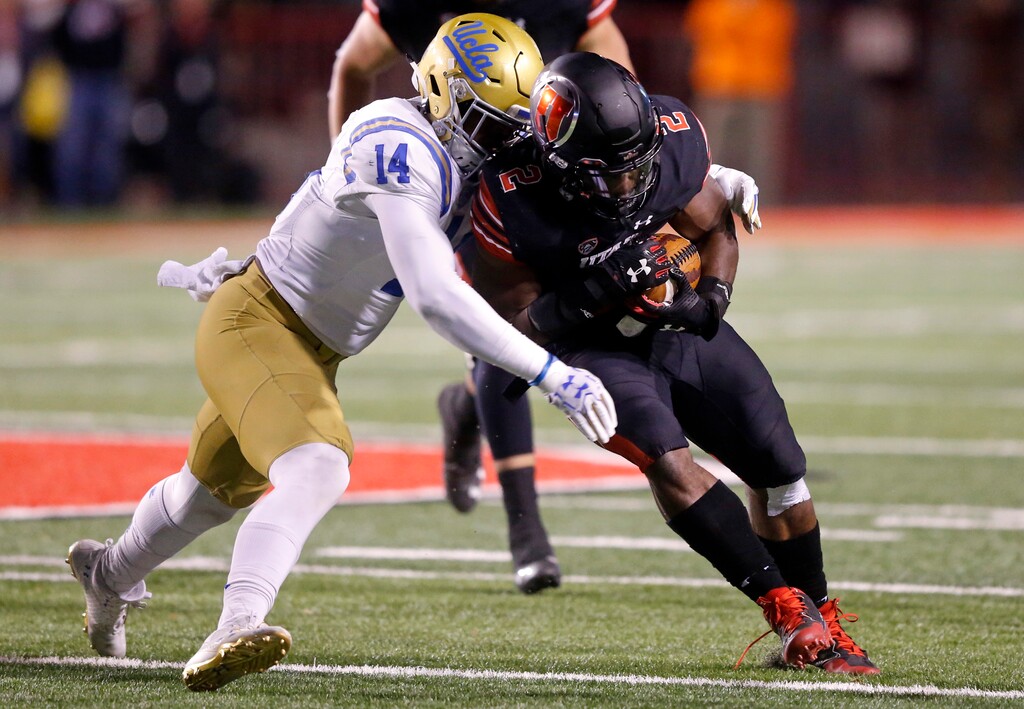 UCLA linebacker Krys Barnes (14) tackles Utah running back Zack Moss during the first half of an NCAA college football game Friday, Nov. 3, 2017, in Salt Lake City. (AP Photo/Rick Bowmer)