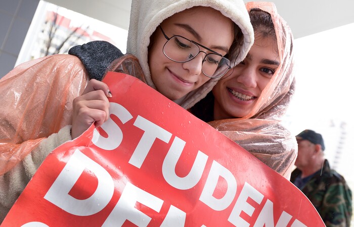 (Leah Hogsten | The Salt Lake Tribune) l-r Brighton graduate Andrea Alarcon and senior Raha Mehrkish huddle to stay warm as they rally with fellow students in support of gun reform at the Wallace F. Bennett Federal Building downtown during the #TownHallForOurLives march, Saturday, April 7, 2018, in response to a national call for town hall meetings issued by David Hogg, one of the leaders of the Parkland FL #NeverAgain movement.