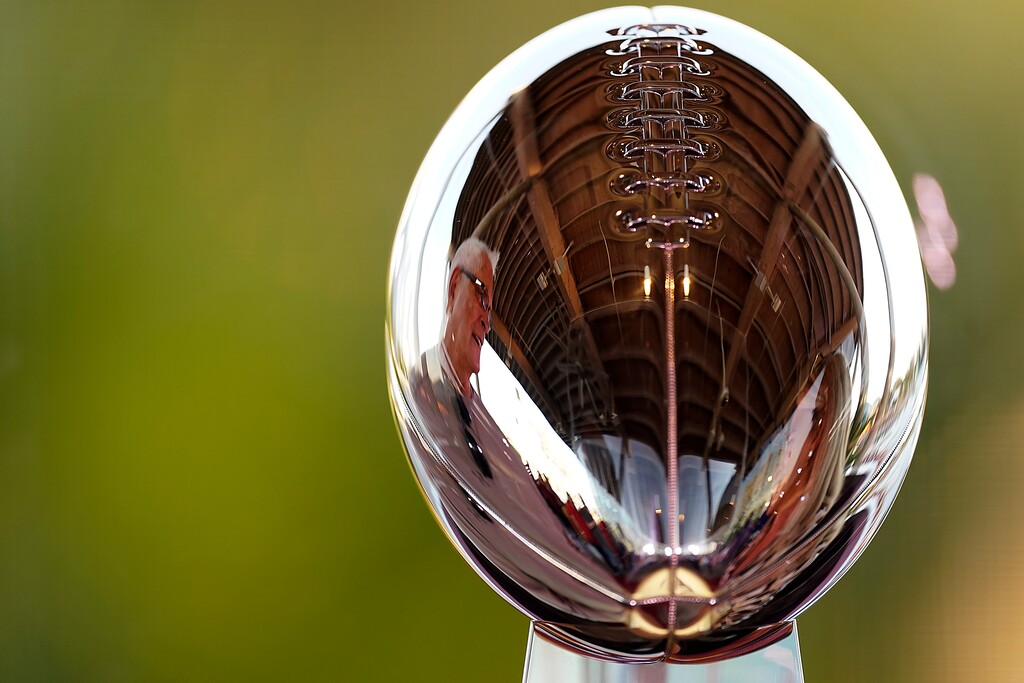 (Charlie Riedel  |  AP) A man is reflected in the Lombardi Trophy at the NFL Experience Thursday, Feb. 4, 2021, in Tampa, Fla. The city is hosting Sunday's Super Bowl football game between the Tampa Bay Buccaneers and the Kansas City Chiefs.